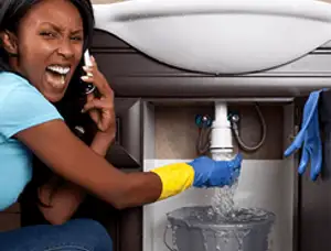 Emergency plumbing repair for a leaking sink drain under a bathroom vanity in Bakersfield, CA