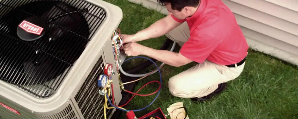 HVAC technician servicing an outdoor air conditioner unit in Bakersfield, CA