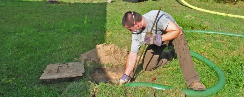 Septic pumping technician servicing a residential septic tank in Bakersfield, CA
